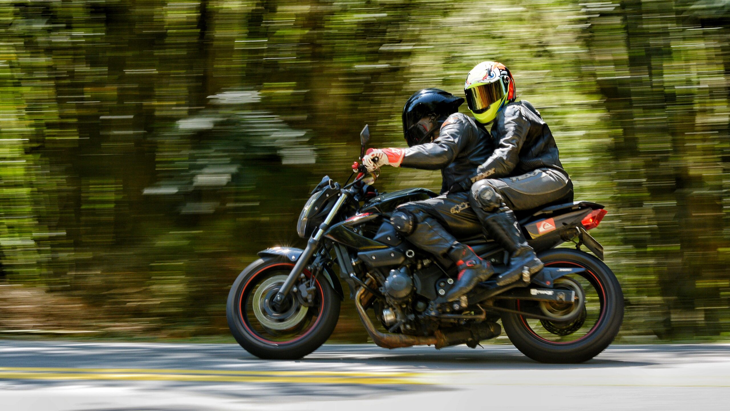 Pareja de motoristas en carretera con casco