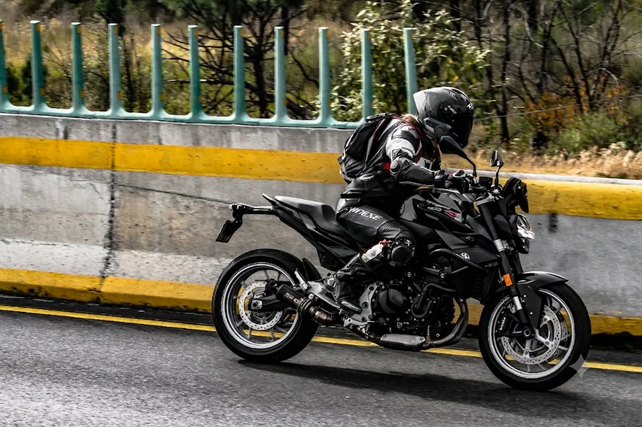Motorista en carretera equipado con casco integrado y un intercomunicador de moto Sena